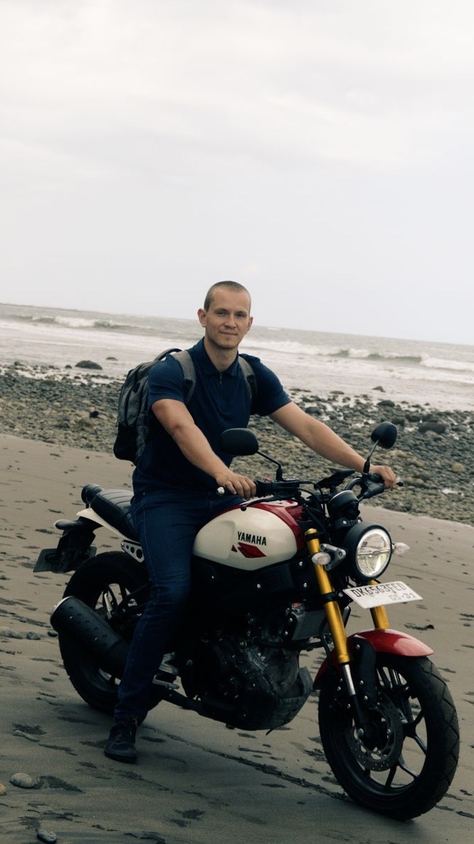 Jacob Preston on a motorbike on a black-sand beach